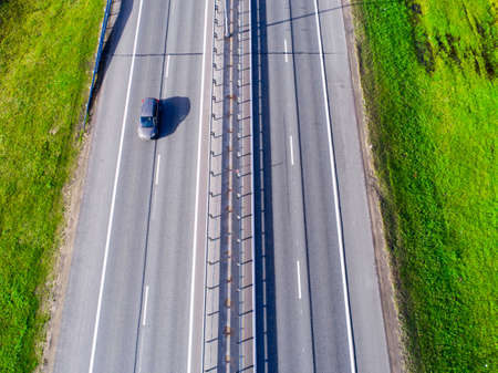 Aerial view of highway in city. Cars crossing interchange overpass. Highway interchange with traffic. Aerial bird's eye photo of highway. Expressway. Road junctions. Car passing. Top view from above. Cars in motionの写真素材