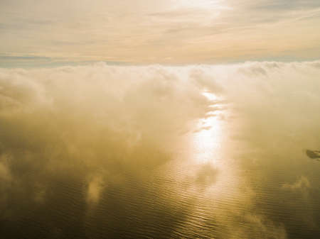 Aerial view White clouds in blue sky. Top view. View from drone. Aerial bird's eye view. Aerial top view cloudscape. Texture of clouds. View from above. Sunrise over the seaの写真素材