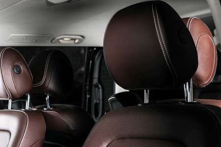 Modern luxury car brown leather interior. Part of leather car seat details with white stitching. Interior of prestige car. Comfortable perforated leather seats. Brown perforated leather. Car detailingの写真素材