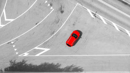 Aerial view of highway. Aerial view of a country road with moving red car. Car passing by. Aerial road. Aerial view flying. Captured from above with a drone. Black and whiteの写真素材