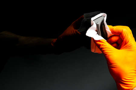 Car polish wax worker hands polishing car. Buffing and polishing vehicle. Car detailing. Man holds a...