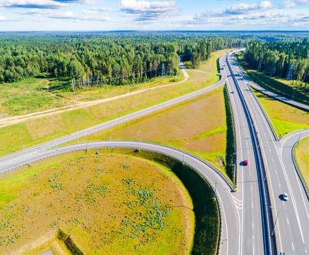 Aerial view of highway in city. Cars crossing interchange overpass. Highway interchange with...