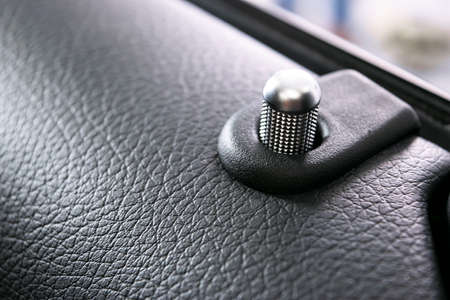 Door handle with lock control buttons of a luxury passenger car. Black leather interior of the luxury modern car. Modern car interior details. Car detailingの写真素材