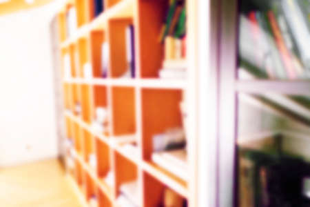 Abstract blurred modern white bookshelves with books. Blur manuals and textbooks on bookshelves in library or in book store. Concept for education. Home interior bokeh background.の写真素材
