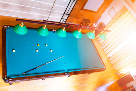 Billiard table close up. Playing billiard. Billiards balls and cue on green billiards table....