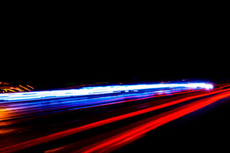 Cars light trails on a curved highway at night. Night traffic trails. Motion blur. Night city road...