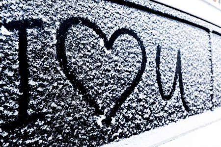I love you Heart symbol on frozen window of the car. Shape of heart drawn on snow on front window of the car. Heart snow. Christmas decorations and accessoriesの写真素材