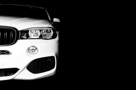 Headlight of a modern white sport car. The front lights of the car. Modern Car exterior details. Car detailing. Isolated on black background. Car detailingの写真素材