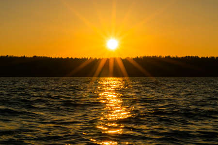 Sunset sky background. Dramatic gold sunset sky with evening sky clouds over the sea. Stunning sky clouds in the sunrise. Sky landscape. Panoramic sky view.の写真素材
