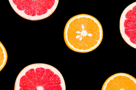 Fresh half cut grapefruit and orange isolated on black background. Close up view. Fruit concept. Healthy lifestyle conceptの写真素材