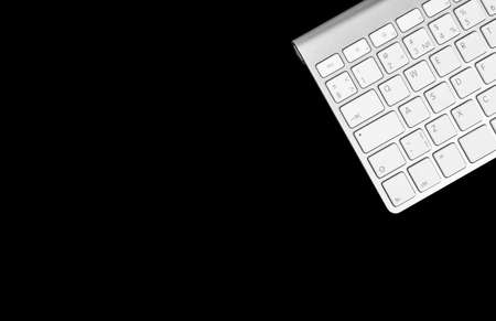 Close up view of a business workplace with wireless computer keyboard isolated on black background. Office desk with copy space. Empty space. Top viewの写真素材