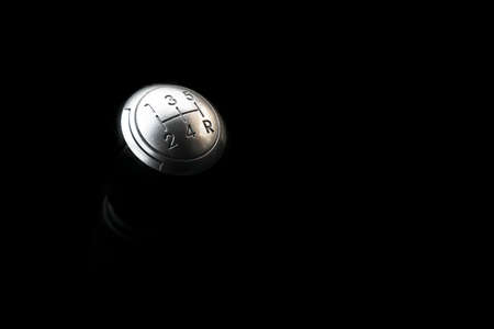 Close up view of a manual gear lever shift isolated on black background. Manual gearbox. Car interior details. Car transmission. Soft lighting. Abstract view. Car detailingの写真素材