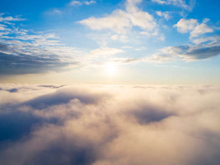 Aerial view White clouds in blue sky. Top view. View from drone. Aerial bird's eye view. Aerial top view cloudscape. Texture of clouds. View from above. Sunrise or sunset over cloudsの写真素材