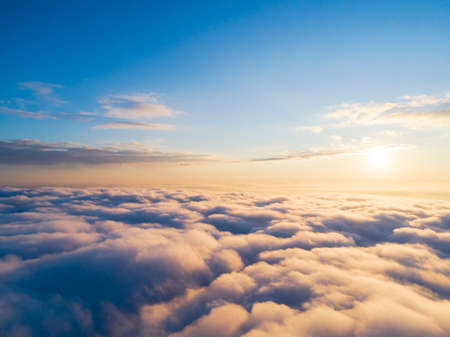 Aerial view White clouds in blue sky. Top view. View from drone. Aerial bird's eye view. Aerial top view cloudscape. Texture of clouds. View from above. Sunrise or sunset over cloudsの写真素材