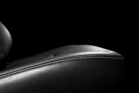 Black leather interior of the luxury modern car. Perforated Leather comfortable seats with stitching isolated on black background. Modern car interior details. Car detailing. Car insideの写真素材
