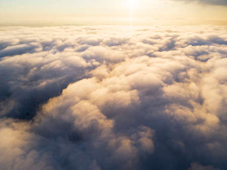 Aerial view White clouds in blue sky. Top view. View from drone. Aerial bird's eye view. Aerial top view cloudscape. Texture of clouds. View from above. Sunrise or sunset over cloudsの写真素材