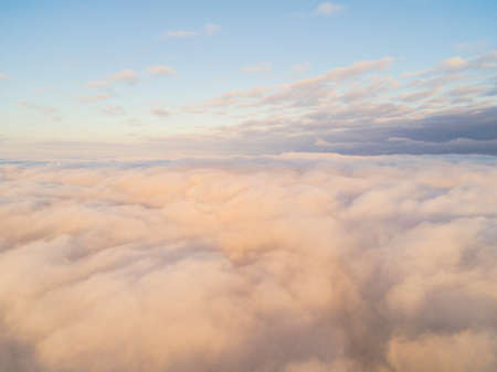 Aerial view White clouds in blue sky. Top view. View from drone. Aerial bird's eye view. Aerial top view cloudscape. Texture of clouds. View from above. Sunrise or sunset over cloudsの写真素材