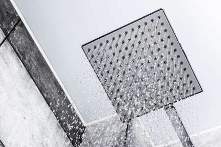 Fresh shower. Head shower with running water. Shower with drops of water. Drops and streams of water. Running water of shower faucet. Falling water dropsの写真素材
