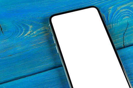 Smartphone with blank screen mock up. Smartphone isolated screen. Mobile phone white screen with copy space on office desk. Empty space for text. Isolated white screenの写真素材