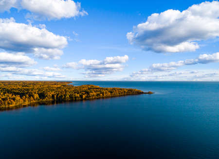 Aerial view of seashore with beach, lagoons. Coastline with sand and water. Landscape. Aerial photography. Birdseye. Sea, beach, sky, clouds. Autumn yellow trees and forestの写真素材