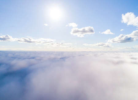 Aerial view White clouds in blue sky. Top view. View from drone. Aerial bird's eye view. Aerial top view cloudscape. Texture of clouds. View from above. Sunrise over cloudsの写真素材
