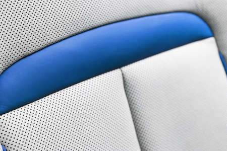 White leather interior of the luxury modern car. Perforated white leather comfortable seats with...