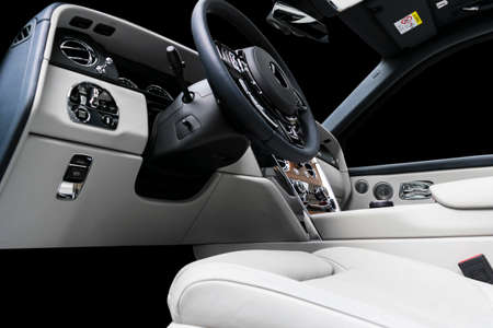 Modern luxury car white leather interior with natural wood panel. Part of leather car seat details...