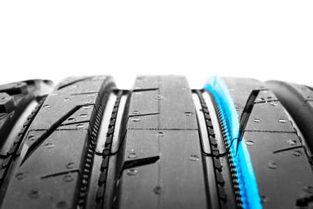 Studio shot of a set of summer car tire on black background. Tire stack background. Car tyre...