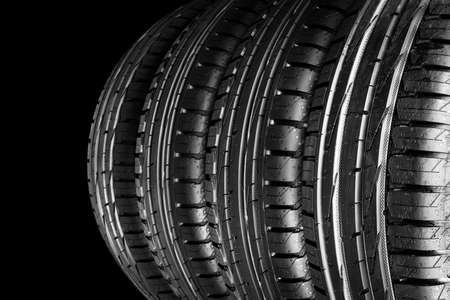 Car tire isolated on black background. Tire stack. Car tyre protector close up. Black rubber tire....