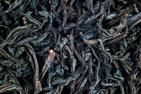 Macro shot of a high quality black tea. Black tea background close up. Leaf closeup. Background of...