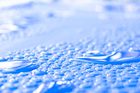 Transparent still water drops on light blue background. Blue water drops. Drops of rain on glass....