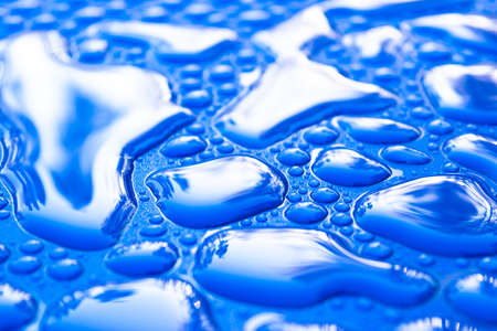 Transparent still water drops on light blue background. Blue water drops. Drops of rain on glass....