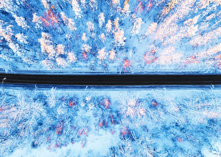 Aerial view of a car on winter road in the forest. Winter landscape countryside. Aerial photography...