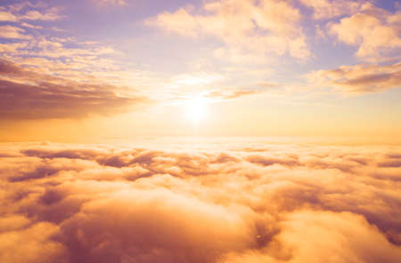 Aerial view White clouds in blue sky. Top view. View from drone. Aerial bird's eye view. Aerial top view cloudscape. Texture of clouds. View from above. Sunrise or sunset over cloudsの写真素材