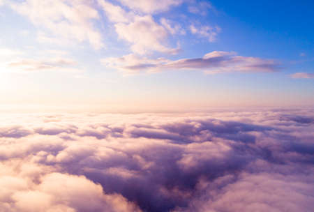 Aerial view White clouds in blue sky. Top view. View from drone. Aerial bird's eye view. Aerial top view cloudscape. Texture of clouds. View from above. Sunrise or sunset over cloudsの写真素材