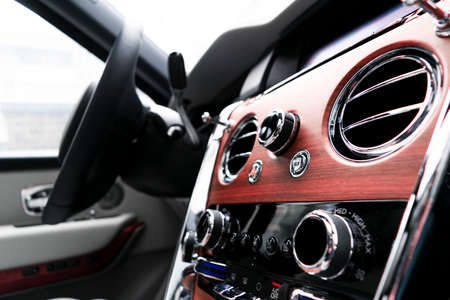 Modern luxury car white leather interior with natural wood panel. Part of leather car seat details...