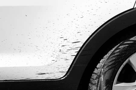 Side view of a very dirty car with bitumen stain. Fragment of a dirty SUV. Dirty headlights, wheel and bumper of the off-road car with swamp splashes on a side panelの写真素材