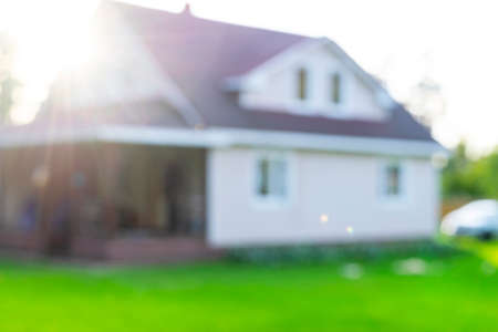 Blurred abstract background of Luxury house. House exterior theme creative abstract blur background with bokeh effect. Blurred house and lawnの写真素材