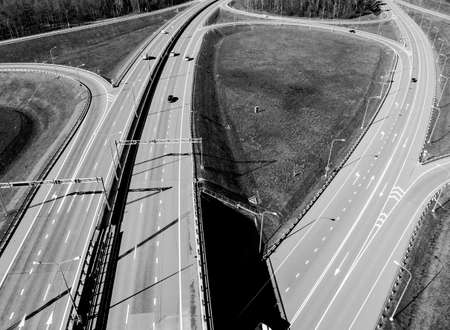 Aerial view of highway and overpass in city. Aerial view of cars crossing interchange overpass....