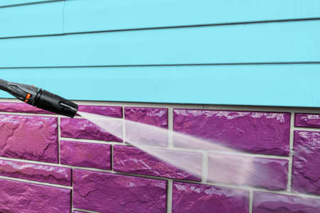 Cleaning service washing building facade with pressure water. Cleaning dirty wall with high pressure...