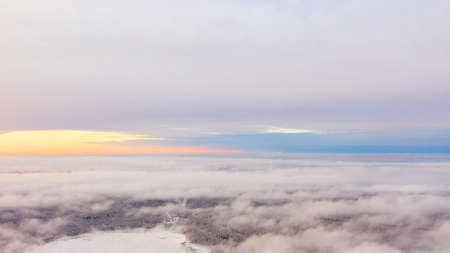 Aerial view White clouds in blue sky. Top view. View from drone. Aerial bird's eye view. Aerial top view cloudscape. Texture of clouds. View from above. Sunrise or sunset over cloudsの写真素材