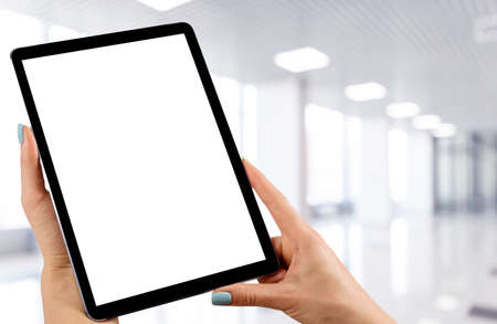 Tablet mockup in woman hand with business centre background. Modern tablet computer mock up with blank white screen. Empty space for text. Copy space. Isolated white screen. Clipping pathの写真素材