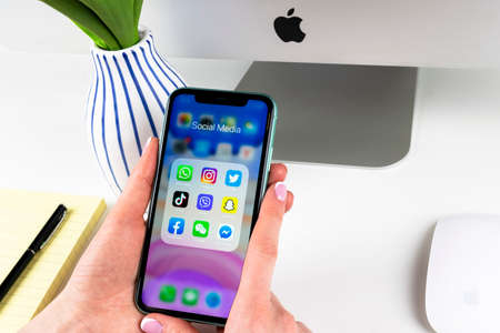 Helsinki, Finland, January 28, 2020: Apple iPhone 11 in woman hands with icons of social media...