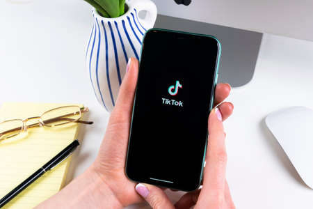 Helsinki, Finland,  January 28, 2020: Tik Tok application icon on Apple iPhone 11 screen close-up in woman hands. Tik Tok icon. tik tok application. Tiktok Social media network. Social media iconのeditorial素材
