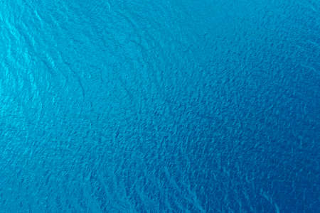 Aerial view of a crystal clear sea water texture. View from above Natural blue background. Blue water reflection. Blue ocean wave. Summer sea. Drone. Top viewの写真素材