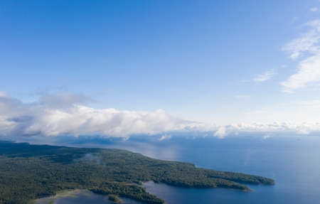 Aerial view clouds over the sea. View seashore and coastline from drone. Aerial top view cloudscape. Texture of clouds. View from above. Sunrise or sunset over clouds. Aerial ocean backgroundの写真素材