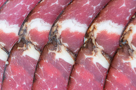 Top view of smoked pork salami chorizo sausages slices background. Macro shot raw smoked salami patternの写真素材