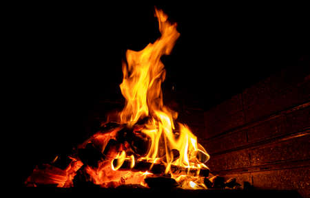 Hot fireplace full of wood. Real Flames from burning logs texture background. Fireplace background....
