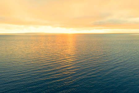Aerial view of a sunset sky background. Aerial Dramatic gold sunset sky with evening sky clouds over the sea. Sky landscape. Aerial photography.の写真素材