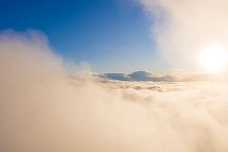 Aerial view gold sunrise over clouds in blue sky. Aerial top view cloudscape. Texture of clouds....